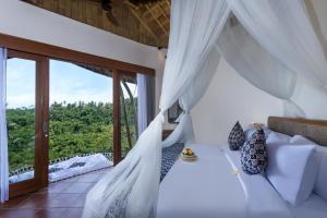 TampaksiringにあるThe Scape Valley Villas by GenuineHostのベッドと大きな窓のある寝室