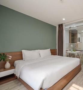 Un dormitorio con una gran cama blanca en una habitación. en Ben's House Boutique, en Da Nang
