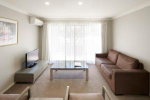 a living room with a couch and a coffee table at Pinnacle Apartments in Canberra