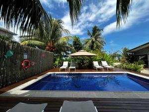 a swimming pool with chairs and an umbrella at Castaway Lodge in Pointe Au Sel 
