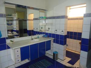 un bagno blu e bianco con un lavandino e uno specchio di Fare D'hôtes Tutehau a Papeete