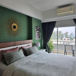 a bedroom with a large bed and a green wall at Patong Tower Apartment Family Room See View in Patong Beach