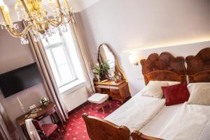 a bedroom with a bed and a window and a chandelier at Urban Stay Salzburg City in Salzburg