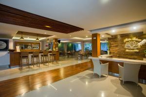 a lobby with a bar with chairs and tables at Mahalaksmi Boutique Hotel in Sanur