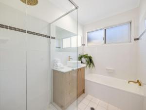 a bathroom with a tub and a sink and a shower at Maroochy 4 Bedroom Family Beachhouse in Maroochydore +12 photos