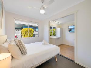 a white bedroom with a white couch and a window at Maroochy 4 Bedroom Family Beachhouse in Maroochydore