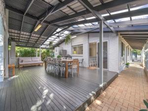 a patio with a table and chairs on a deck at Maroochy 4 Bedroom Family Beachhouse in Maroochydore