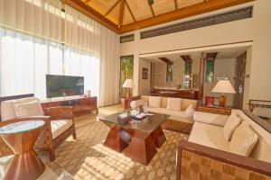 a living room with a couch and a table at Grand Metropark Villa Resort Sanya Yalong Bay - Beach shuttle and Singer performance in Sanya