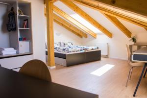 una camera con letto in una stanza con travi in legno di Belgicka Executive Apartments a Praga