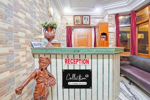 a mural of a statue at a reception counter in a building at Super Collection O Mathura Near Railway Station in Mathura