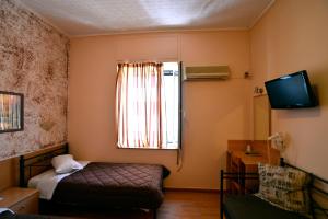 ピレウスにあるエレクトラ ホテル ピレウスのベッドと窓が備わる小さな客室です。