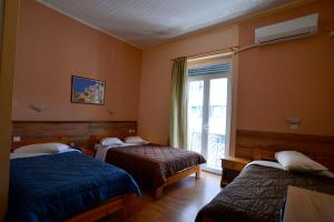 a hotel room with two beds and a window at Electra Hotel Piraeus in Piraeus