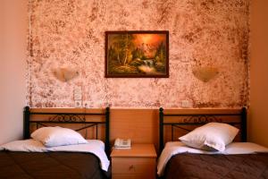 two beds in a room with a painting on the wall at Electra Hotel Piraeus in Piraeus