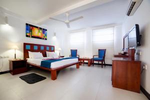 a hotel room with two beds and a desk at Pigeon Island Beach Resort in Nilaveli
