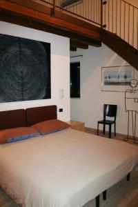 a bedroom with a large bed and a black chair at Agriturismo Nicobresaola in Sommacampagna