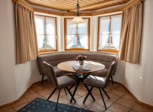 a table and chairs in a room with windows at Haus Verena Mittenwald in Mittenwald