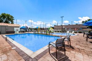 a large swimming pool with two chairs next to it at Sleep Inn & Suites Rehoboth Beach in Rehoboth Beach