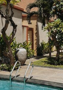 una piscina con 2 sillas de metal al lado de una casa en Gelis Gede Cottages, en Uluwatu