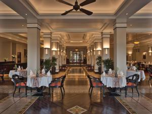 a restaurant with white tables and chairs and a ceiling at Azerai La Residence, Hue in Hue