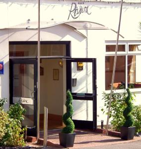 a front door of a building with a bush in front at The Riviera Hotel & Apartments - Alum Chine in Bournemouth