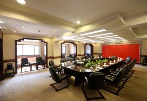una gran sala de conferencias con una mesa larga y sillas en Ying Yuan Hotel, en Jiading