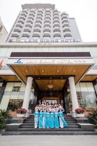 a group of people standing in front of a building at Lam Giang Hotel in Vinh