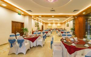 a banquet hall with white tables and blue bows at Lam Giang Hotel in Vinh