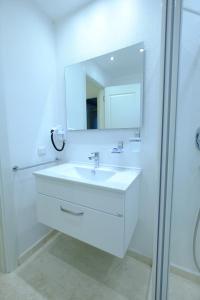 Un baño blanco con lavabo y espejo. en Smart Aparts, en Kalkan