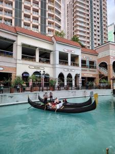 a gondola in the water in front of a building at Stylish New Studio at McKinley Hill BGC Free Netflix in Manila