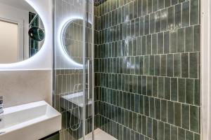 a bathroom with a sink and a shower with green tiles at Effe Luxury Rooms in Rome +45 photos