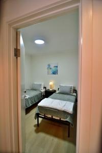 a room with two beds and a mirror at 3-Bedroom Townhouse in Heart of Adelaide with Parking in Adelaide