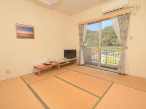 a living room with a large window and a television at Tokashiku Marine Villege in Tokashiki