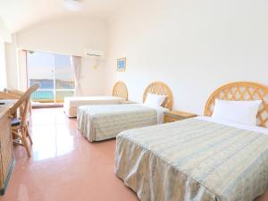 a hotel room with two beds and a balcony at Tokashiku Marine Villege in Tokashiki +19 photos