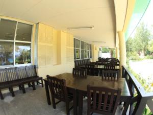 a restaurant with wooden tables and chairs and windows at Tokashiku Marine Villege in Tokashiki