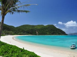 a boat sitting on a beach next to the ocean at Tokashiku Marine Villege in Tokashiki