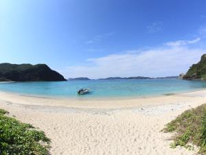 a boat in the water on a beach at Tokashiku Marine Villege in Tokashiki