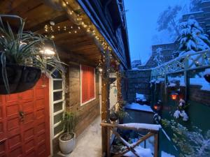 a house with a red door and christmas lights at MeenaBagh Villa Rooms & Cafe in Shimla