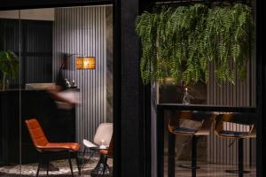 a room with chairs and a table with a plant at BRYQS Hotel KL Sentral in Kuala Lumpur