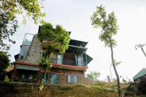 a building on a hill with plants on it at Fifth Estate in Vagamon