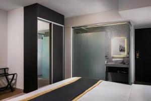 a bedroom with a bed and a bathroom with a sink at BRYQS Hotel KL Sentral in Kuala Lumpur +31 photos