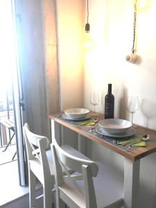a table with two white plates and wine glasses at Le Casette Gargallo 2 - Ortigia in Siracusa