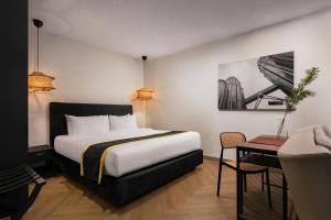 a hotel room with a bed and a table at BRYQS Hotel KL Sentral in Kuala Lumpur