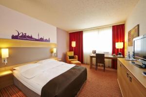 a hotel room with a bed and a desk at The Rilano Hotel Stuttgart Böblingen in Böblingen