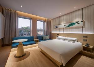 a bedroom with a large white bed and a blue couch at Mayfield Hotel Seoul in Seoul
