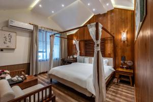 una camera da letto con letto a baldacchino e un soggiorno di Pillow Window & Listen to Rain Hostel Museum Branch Pingjiang Road, Suzhou a Suzhou