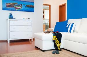 a living room with a white couch and a dresser at Ericeira Apartment - Blue Sea in Ericeira
