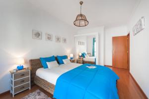 a bedroom with a large bed with a blue blanket at Ericeira Apartment - Blue Sea in Ericeira
