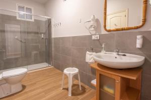 Un baño con lavabo, inodoro y ducha. en Pensión Casa Castelao 31 O Grove, en O Grove