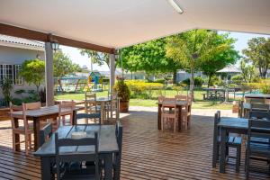 une terrasse avec des tables et des chaises ainsi qu'une aire de jeux dans l'établissement Pine Lodge George, à George 27 autres photos