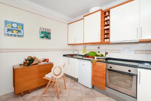 une cuisine avec des placards blancs et un comptoir dans l'établissement Ericeira Apartment - Blue Sea, à Ericeira